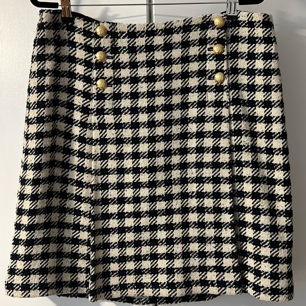 Navy and white checkered skirt with gold button accents.